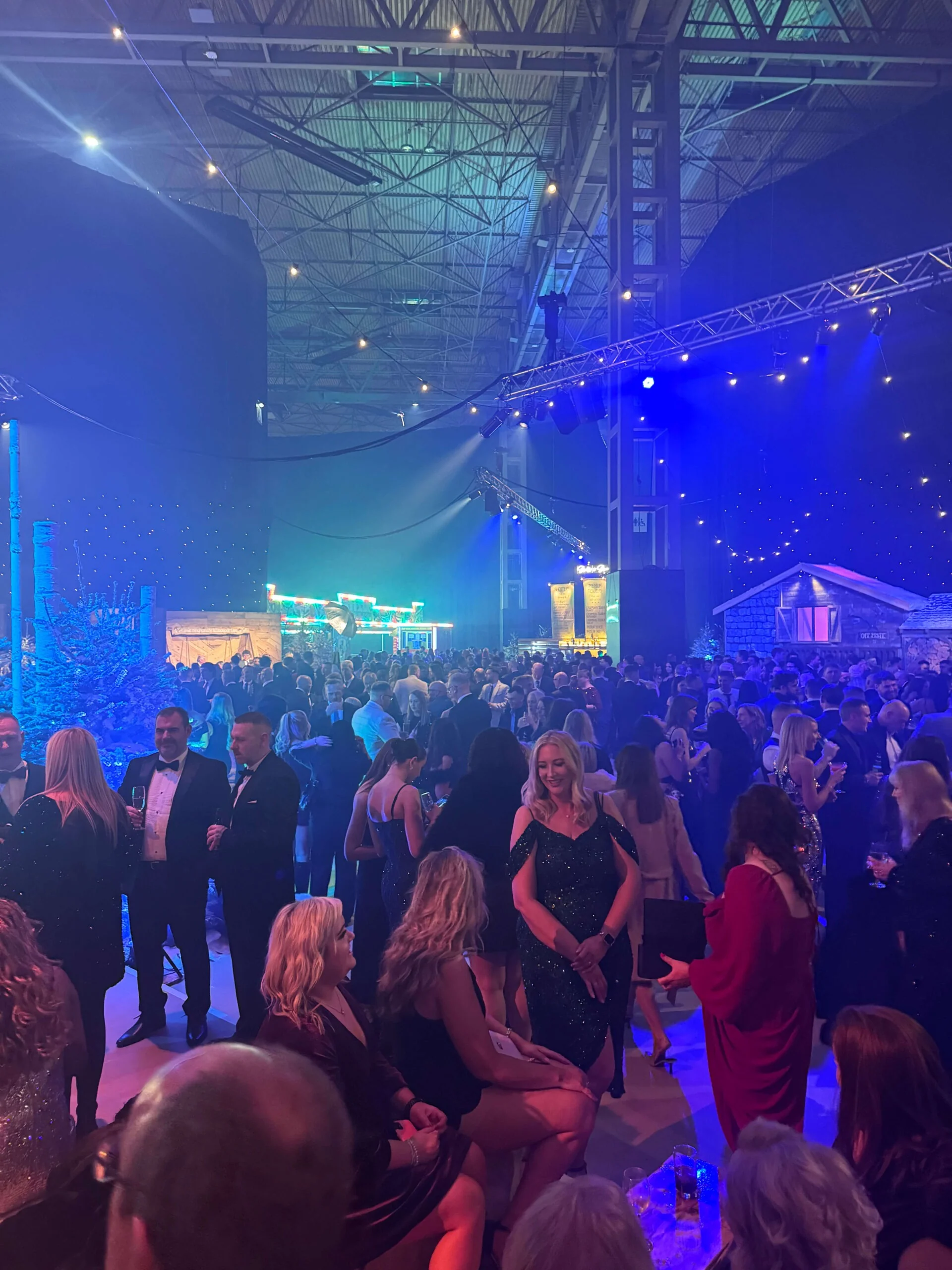 Guests dancing at a corporate event under blue stage lighting